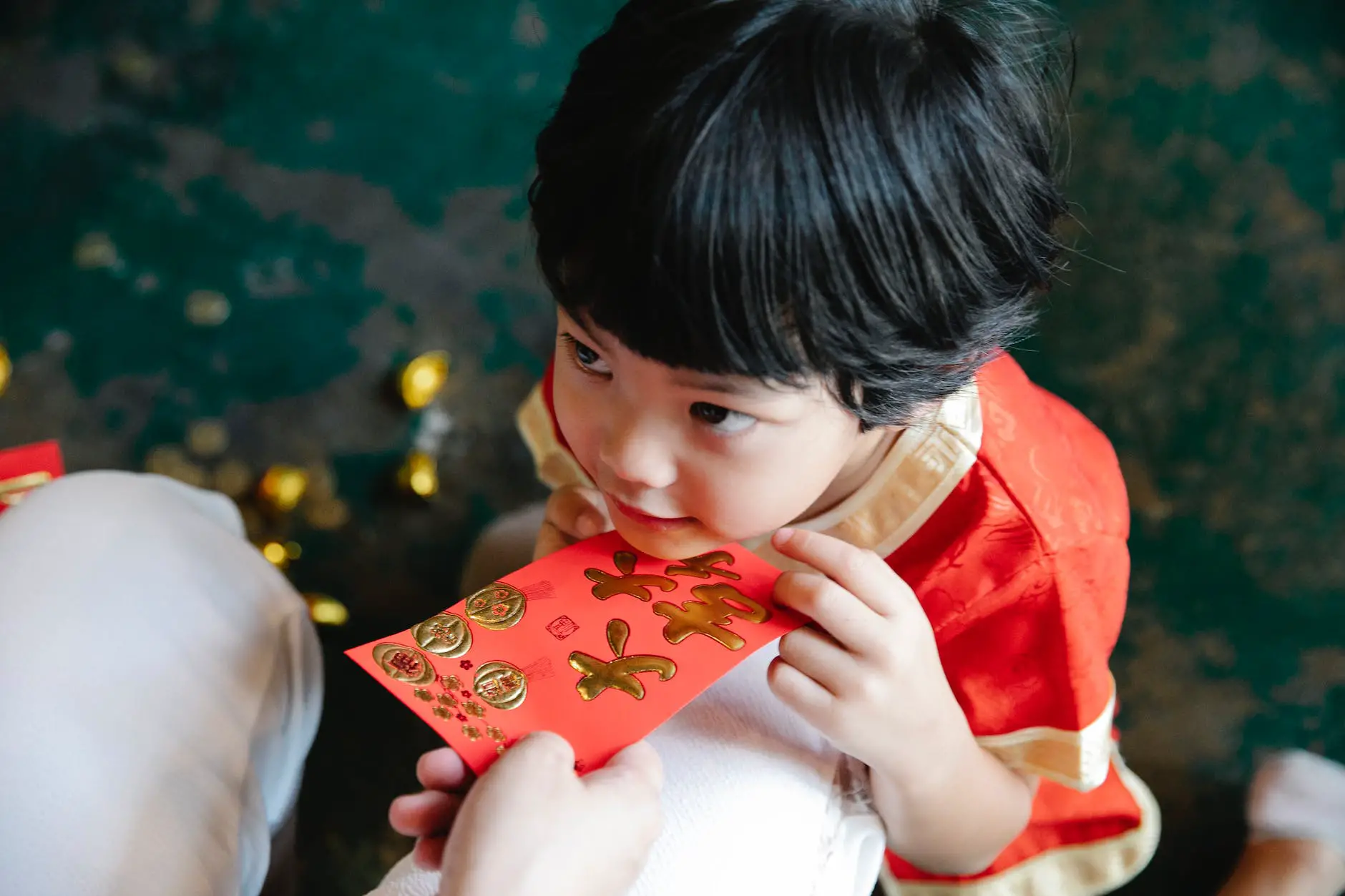 crop mother giving hongbao red packet to son during new year party
